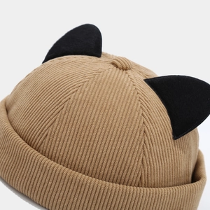 Detail shot of brown corduroy docker cap featuring cute black cat ear decorations