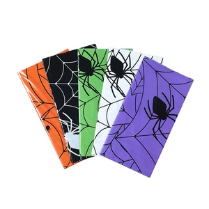 Detail of colorful folded Halloween spider web tablecloths in orange, black, and green