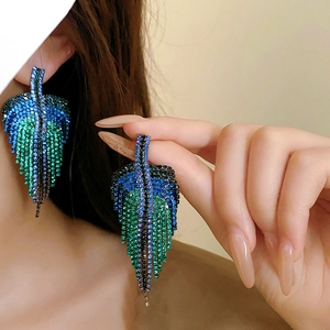 Detail of leaf-shaped tassel earrings featuring gradient blue and green crystal rhinestones