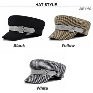 Detail view of stylish flat top cadet hats with rhinestone buckles and houndstooth patterns
