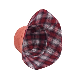 Women's reversible bucket hat with solid orange exterior and red plaid interior