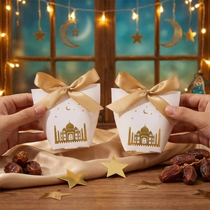 Detail of white candy box with gold foil castle patterns and gold satin ribbon bow