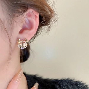 Detailed close-up of gold-plated zircon stud earrings with deer antlers and Fu character