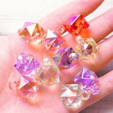 Close-up of colorful faceted geometric acrylic beads with hanging loops for DIY jewelry