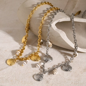 Detail of 18k gold and silver ocean series bracelets with seashell pendants on white stand