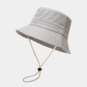 Detail of laser-cut ventilation holes and woven chin strap on light grey hiking bucket hat
