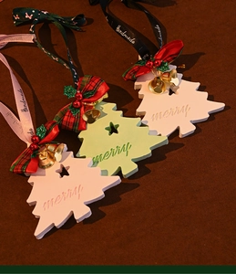Detailed view of wood Christmas tree ornaments with bows and bells in pastel colors
