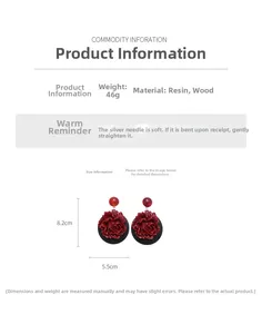 Détail de grandes boucles d'oreilles fleur en résine rouge avec base ronde en bois noir