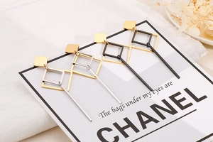 Detail of geometric drop earrings with square frames and metal bars in gold and silver