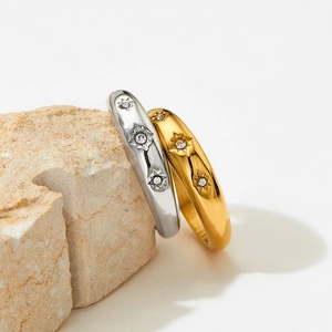 Polished stainless steel rings with gold and silver finishes and north star starburst design