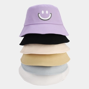 Vertical stack of multi-color cotton bucket hats with a smiley face print detail
