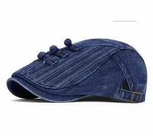 Detail of dark blue denim newsboy cap with traditional knots and metal buckle strap