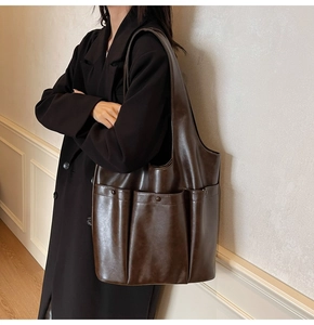 Detail view of deep brown PU leather tote bag with functional double pockets and soft finish