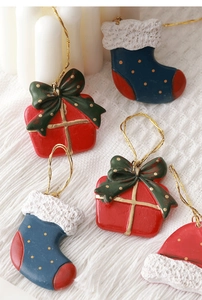 Miniature resin Christmas charms featuring gift boxes, socks and hats with golden cords