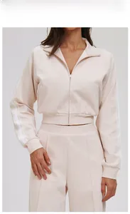 Detail of oatmeal apricot tracksuit featuring striped sleeves and stitched leg creases
