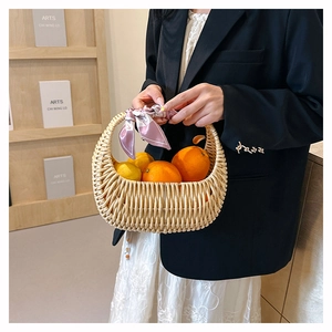 Detail of hand-woven straw basket bag with decorative floral scarf on the handle