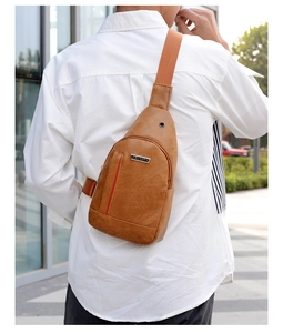 Close-up of light brown PU leather men's chest bag with woven strap and headphone port