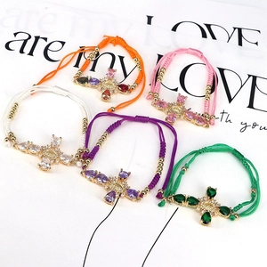 Detail of adjustable cotton ropes with colorful zircon cross charms and religious icons