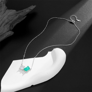 Silver titanium steel necklace with square emerald and zircon stones on artistic stand
