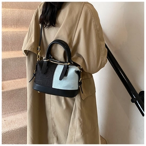 Fashionable denim patchwork crossbody bag styled with a trench coat on a model
