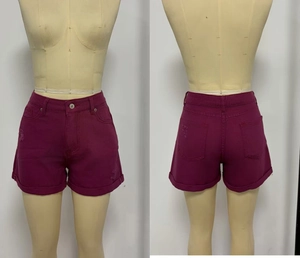 Dettaglio di pantaloncini di jeans viola a vita alta con orli sfrangiati e look vintage