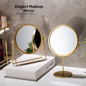 Detail of minimalist gold round makeup mirrors with U-shaped and column base stands