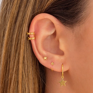 Detail of gold star ear cuff and earring set worn on ear for stacking style
