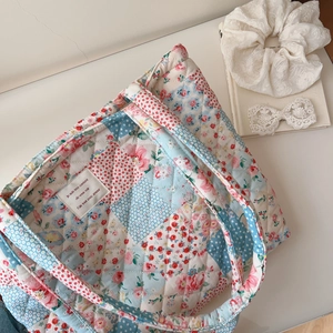 Detailed view of floral quilted cotton tote bag with colorful patchwork and soft texture