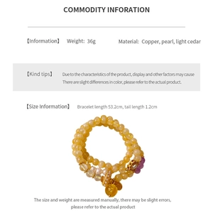 Detail view of multi-layer bracelet with pearls, yellow wood beads and gold charm