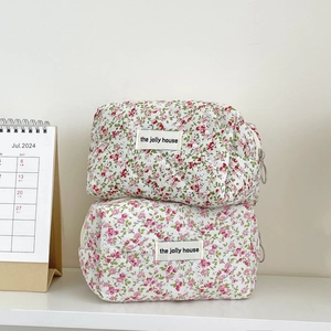 Detail of floral quilted cotton makeup bags with a metal zipper and rhombic stitching