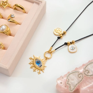 Detailed flat lay of evil eye gold pendant necklace with vintage 18K stainless steel accents