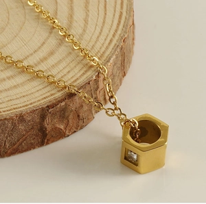 Macro shot of gold hexagon pendant necklace with zircon stone on wooden display
