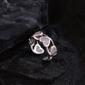 Elegant silver open ring featuring hollow pink enamel hearts on a charcoal background