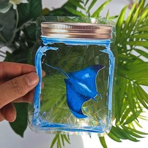 Close-up of holographic manta ray suncatcher sticker reflecting rainbow colors on glass