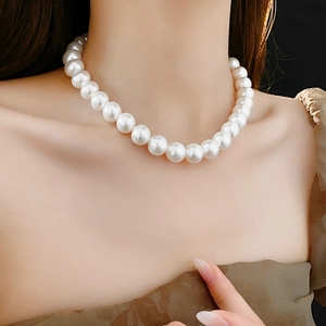 Gros plan d'un collier de perles élégant porté par un mannequin de style minimaliste
