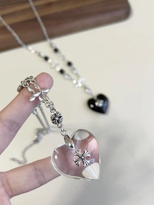 Close-up of heart pendants with silver cross motifs on beaded stone necklaces