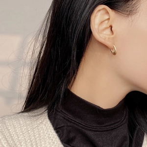 Minimalist 925 sterling silver U-shaped oval hoop earrings in gold worn by a model