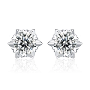 Macro detail of snowflake-shaped silver stud earrings with sparkling moissanite stones