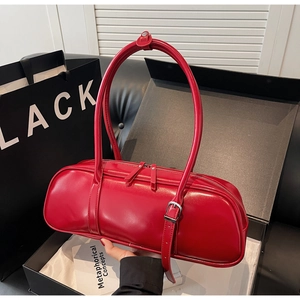 Detail of red cylindrical baguette bag with smooth leather finish and dual zippers
