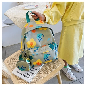 Detailed view of floral children backpack on wicker chair with round coin pouch charm