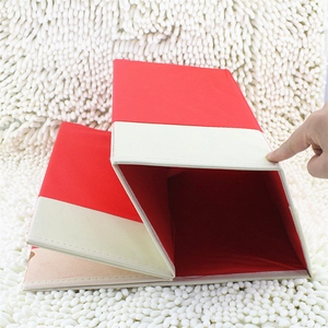 Detail view of red non-woven Christmas tree collar box on white faux fur carpet