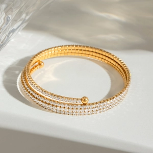 Gold multi-layer stainless steel bangle featuring zircon micro-pave on water ripple background