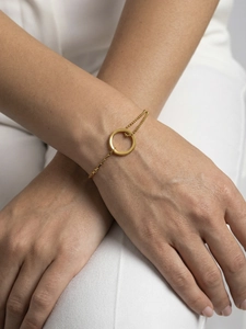 Detail of gold geometric circle bracelet with box and bead chains on woman's wrist