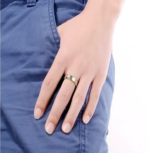 Close-up of bicolor Forever Love steel ring on finger near denim jeans pocket