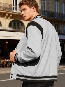 Detail of light grey fleece baseball jacket with black striped collar and metal buttons