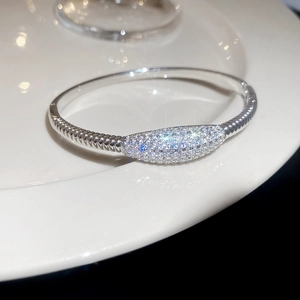 Vue détaillée du bracelet cœur en argent avec pierres de zircone sur une assiette en céramique