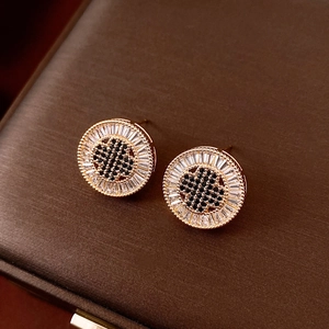 Detailed view of 18k gold plated round studs with black and white zircon inlay