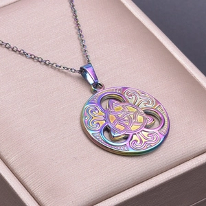 Macro view of a colorful rainbow-plated Celtic knot pendant in a pink velvet jewelry box