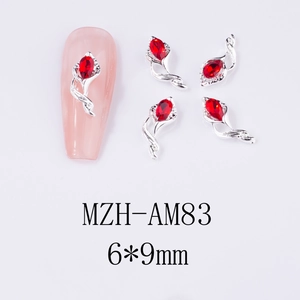 Macro shot of 6x9mm vine-shaped alloy nail charms with red teardrop rhinestones