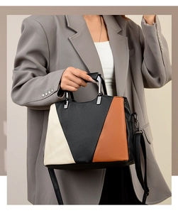 Detail of tricolor leather tote bag with metallic handles and textured finish